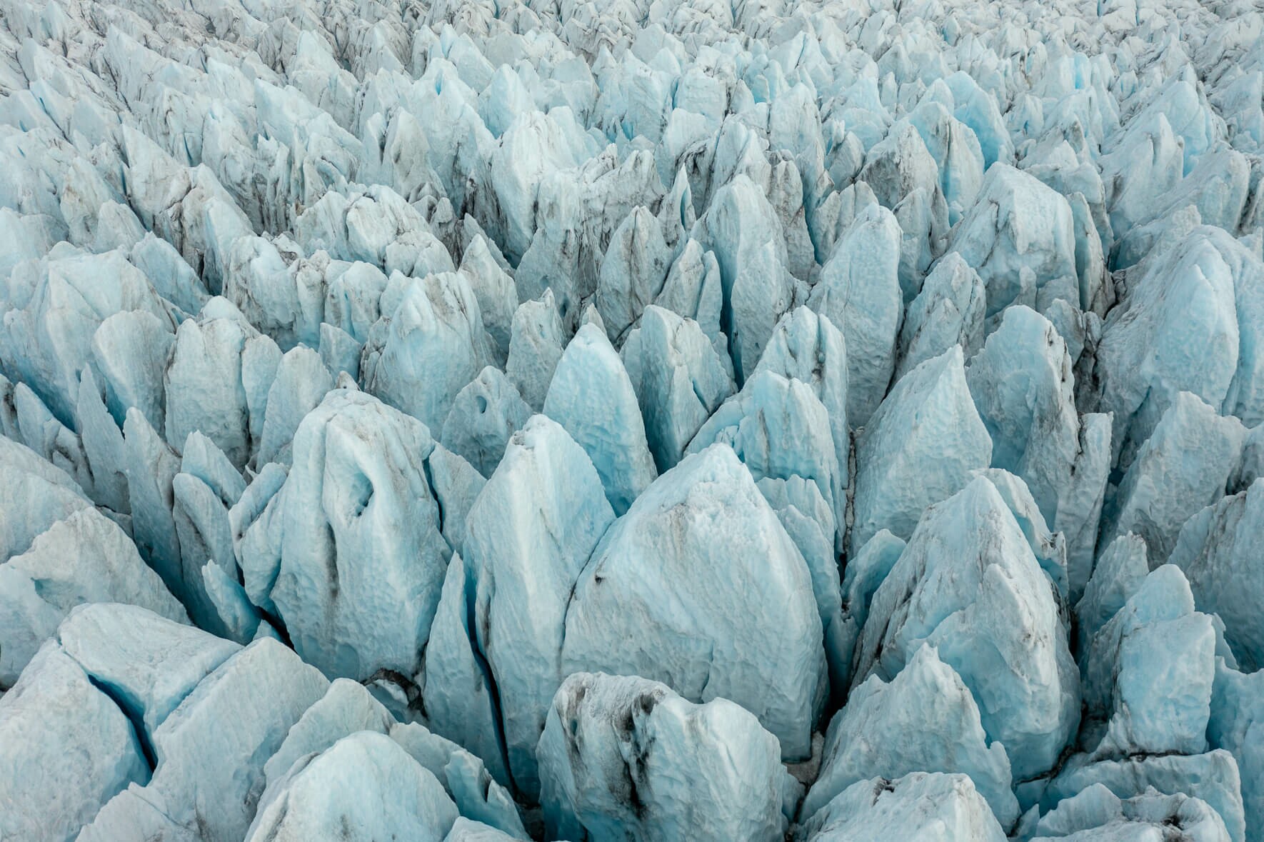 Aerial view of a glacier in Iceland with glacier towers and deep crevasses