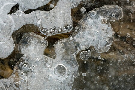 Macro photograph of air bubbles in the ice of a small creek in southern Norway