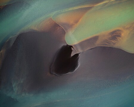 Aerial photography of a glacial river in Iceland with a black sandbank