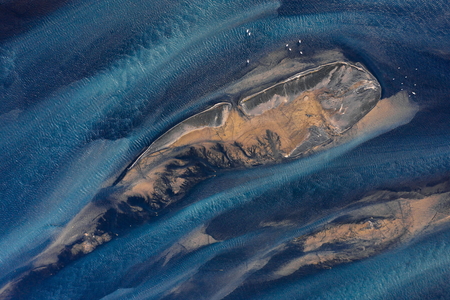 Abstract colors of Holsa river on the south coast of Iceland with small sandbanks and seagulls