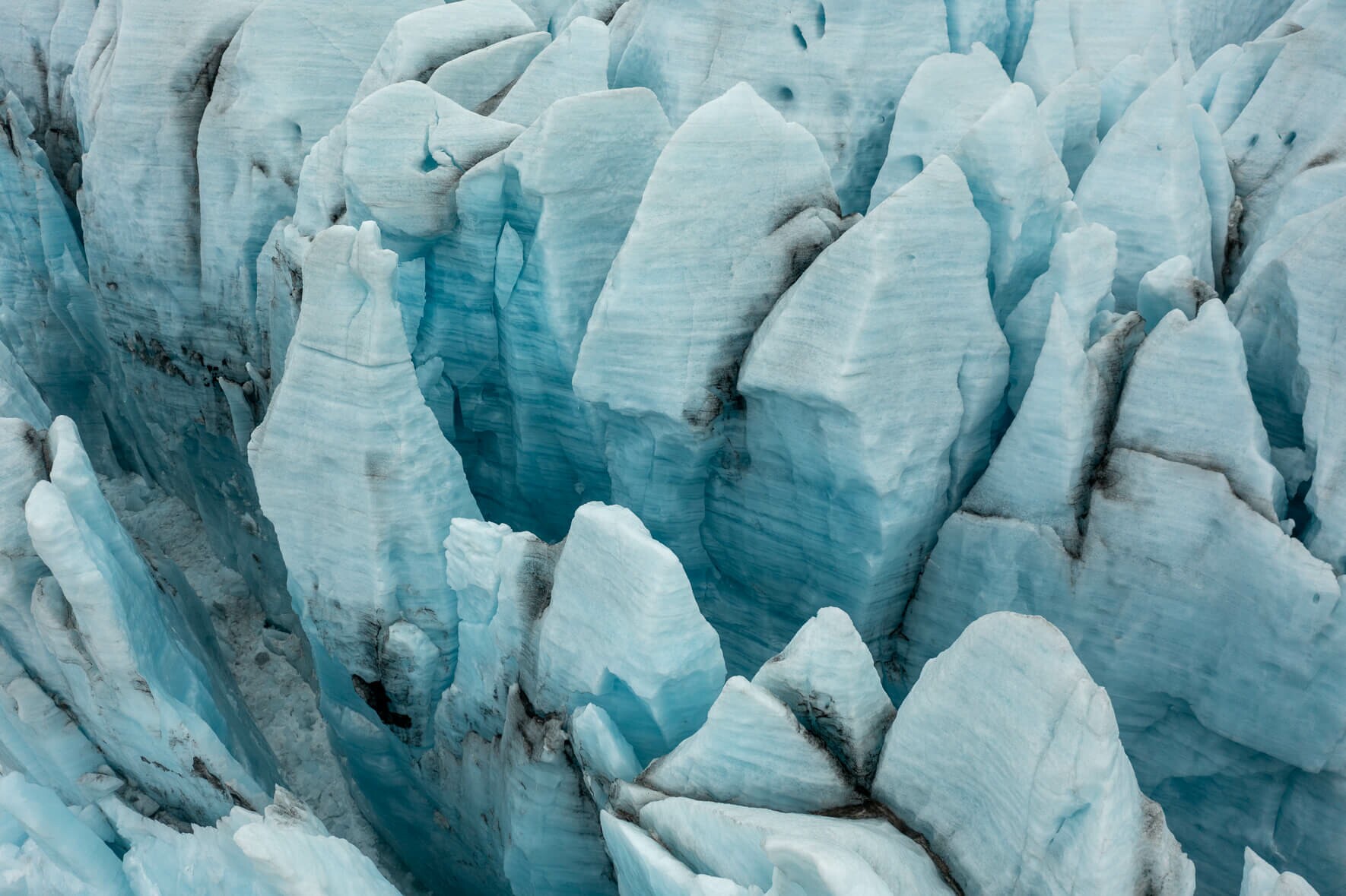 Aerial view of Fjallsjökull glacier in Iceland with abstract glacier towers and crevasses