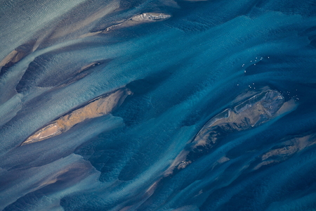 Aerial photography of Holsa river on the south coast of Iceland with small sandbanks and seagulls