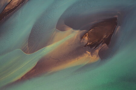 Colorful aerial photograph of a glacial river in Iceland with a sand island in the middle