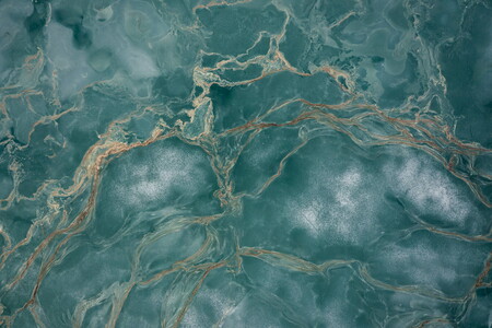 Aerial view of a thawing lake in Norway with ice and flower pollen forming streaks on the water