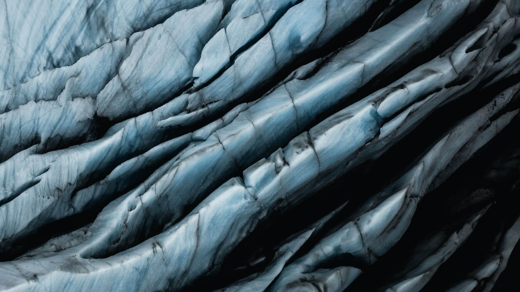 Aerial drone view of Svínafellsjökull glacier with black ash