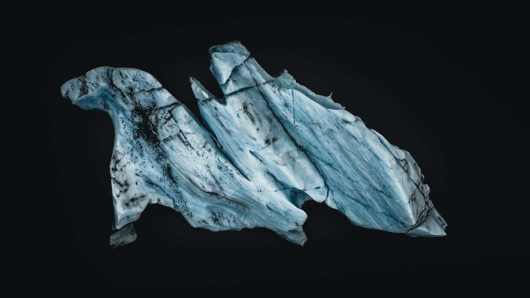 Aerial view of an iceberg in dark glacier waters in Iceland