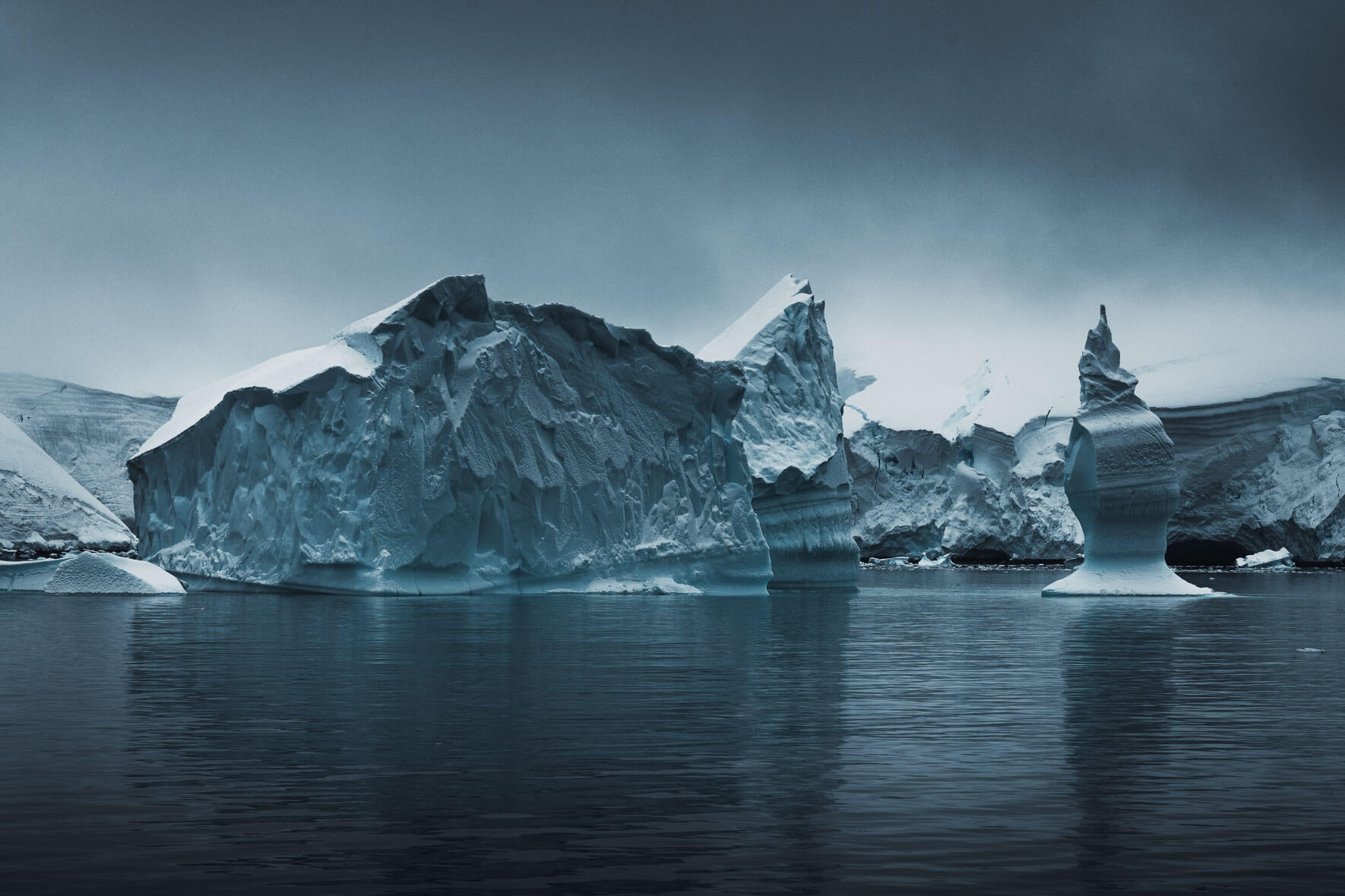 Icebergs broken off from the Antarctic Peninsula with dark clouds