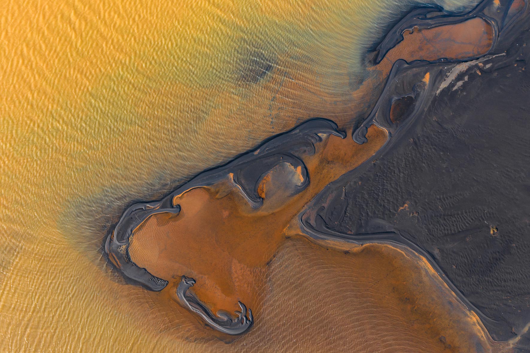 Aerial photograph of abstract lake with dark shoreline in Iceland