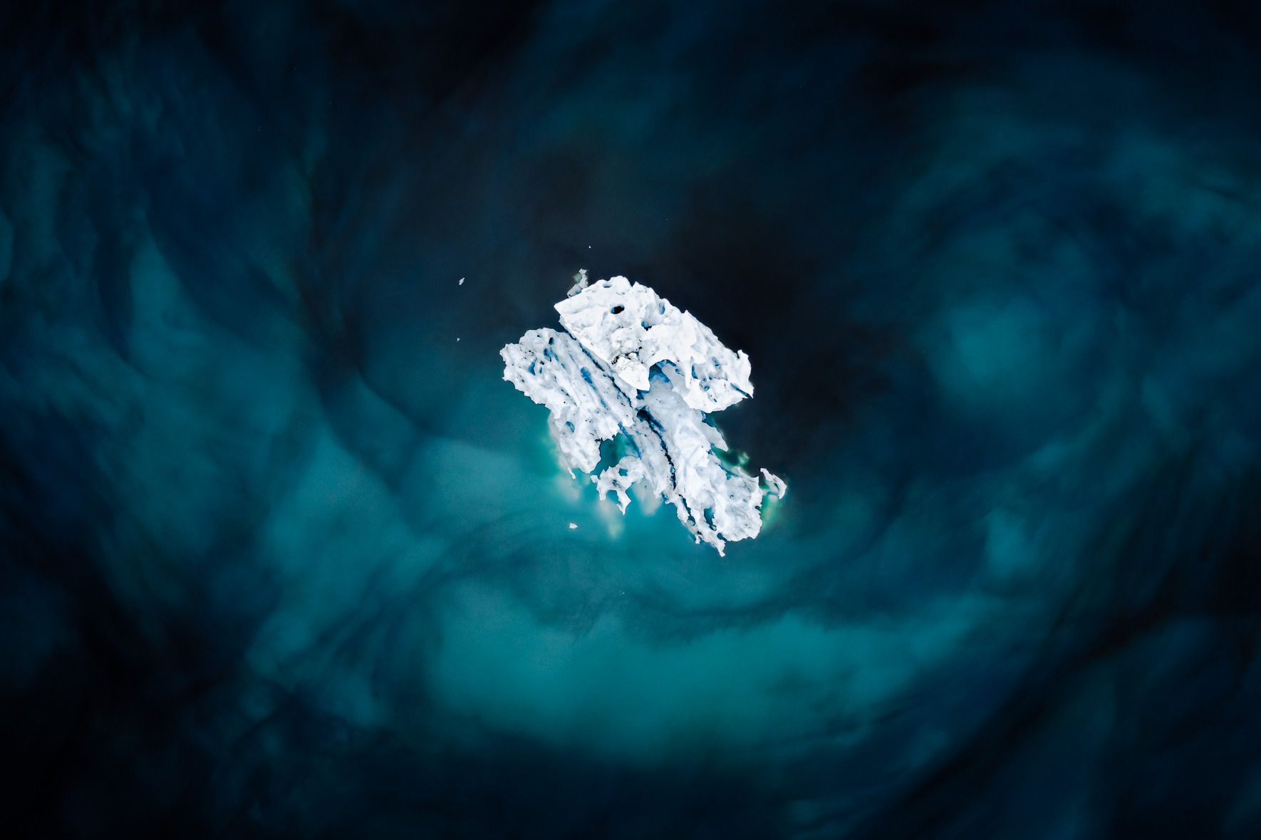 Iceberg floating in dark blue glacier lagoon