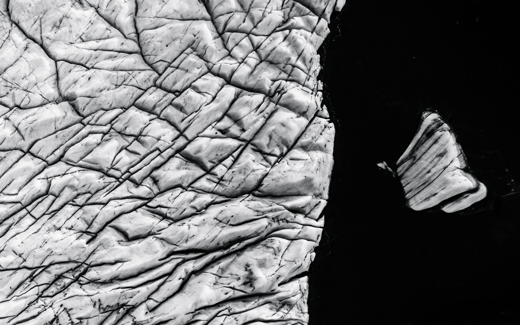 Aerial view of Svínafellsjökull glacier with iceberg in black and white