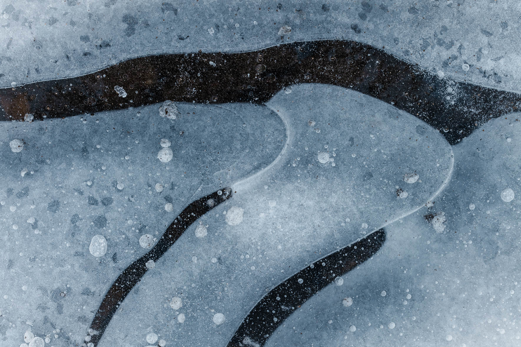 Abstract Macro Photography of Frozen Puddle with Air Bubbles