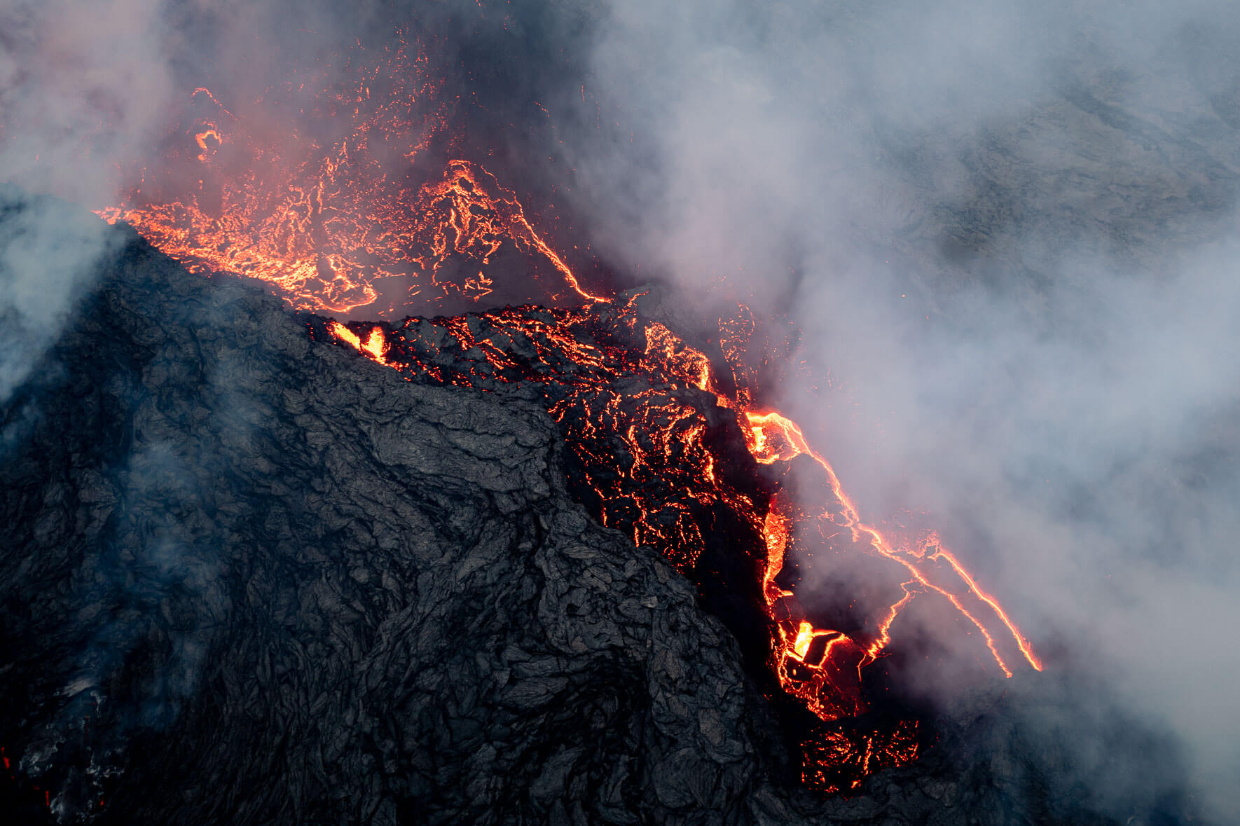 The crater lake of the eruption at Mount Fagradalsfjall in Iceland with steam