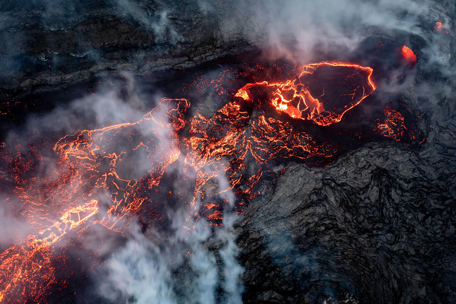 The crater lake of the eruption at Mount Fagradalsfjall in Iceland with steam