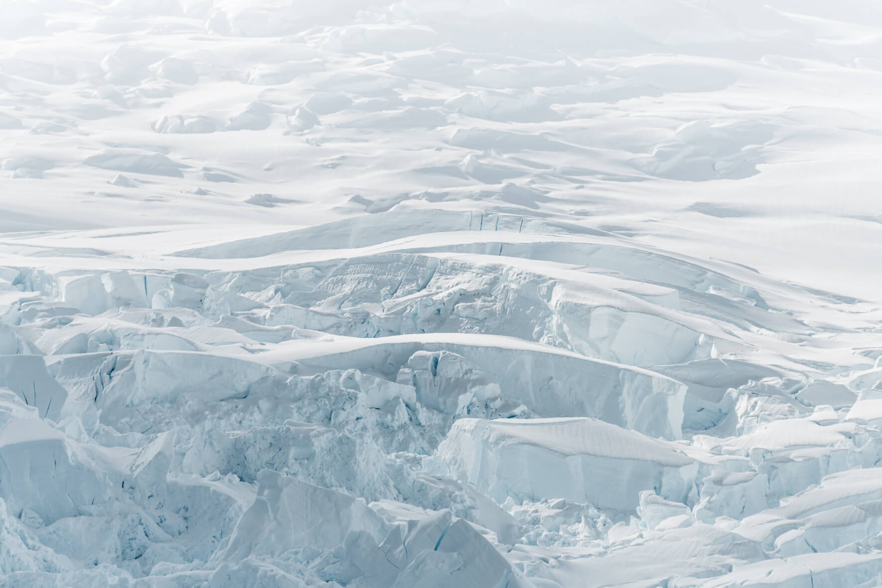 Glacier in Antarctica with crevasses in bright sunlight