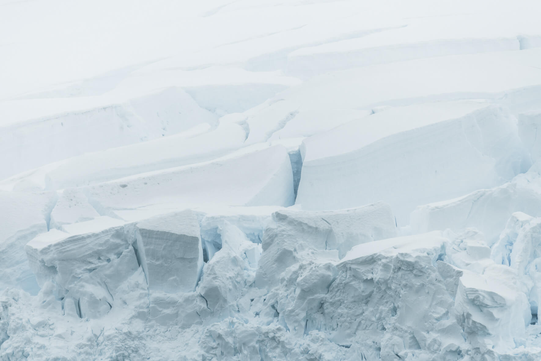 Details of a glacier in Antarctica in bright sunlight with haze over the ice