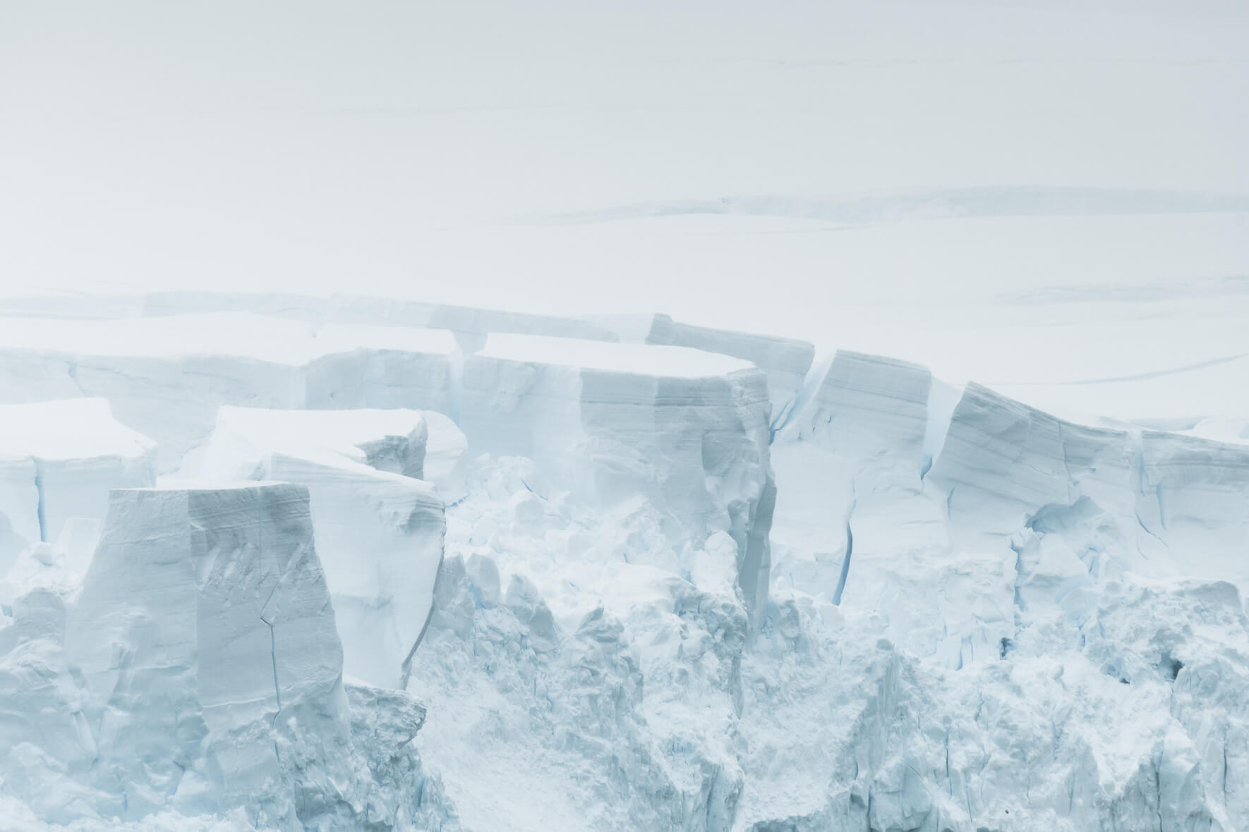 Glacier towers in Antarctica in bright sunlight with haze over the ice