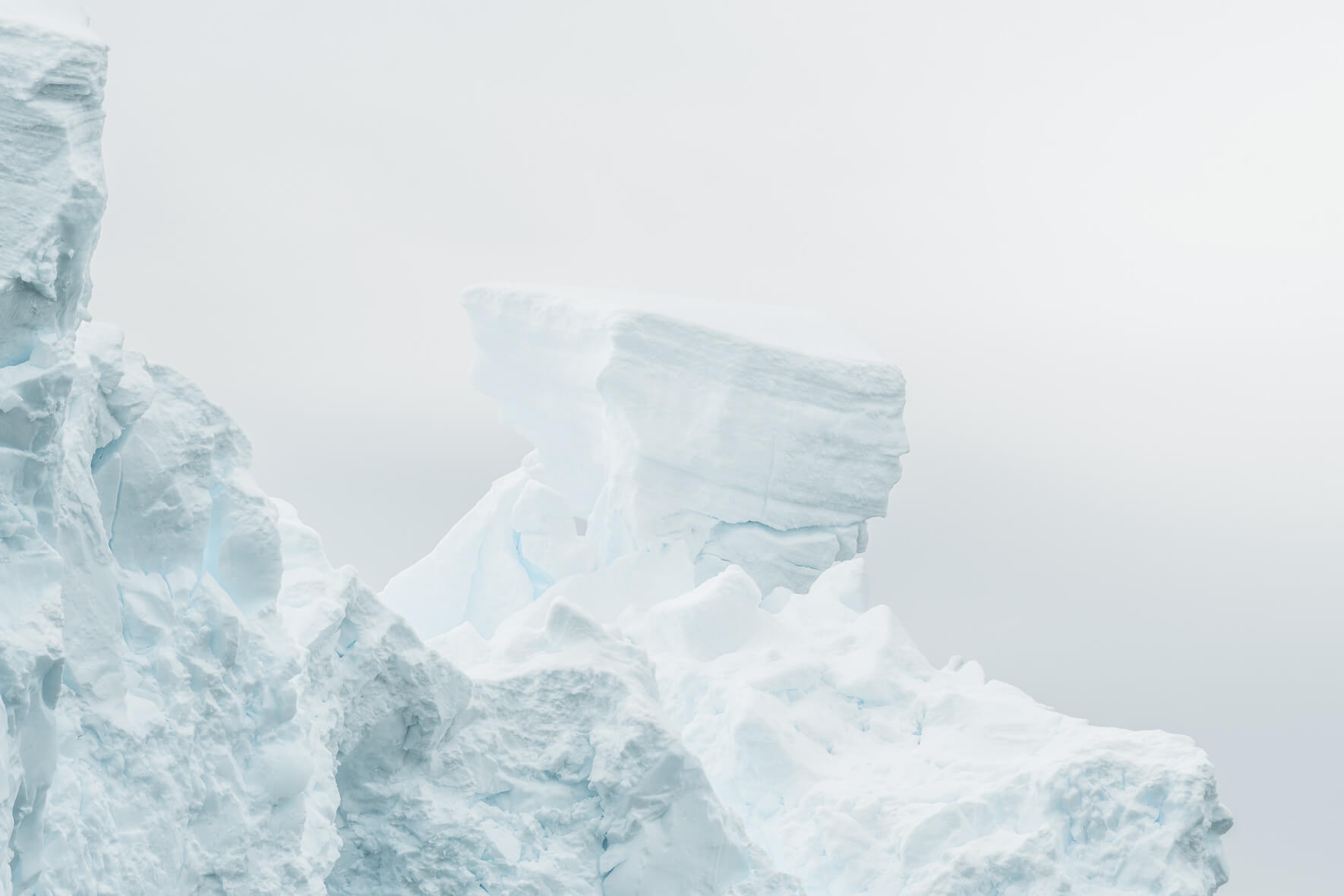 Bright ice of a glacier in Antarctica in sunlight and almost white sky