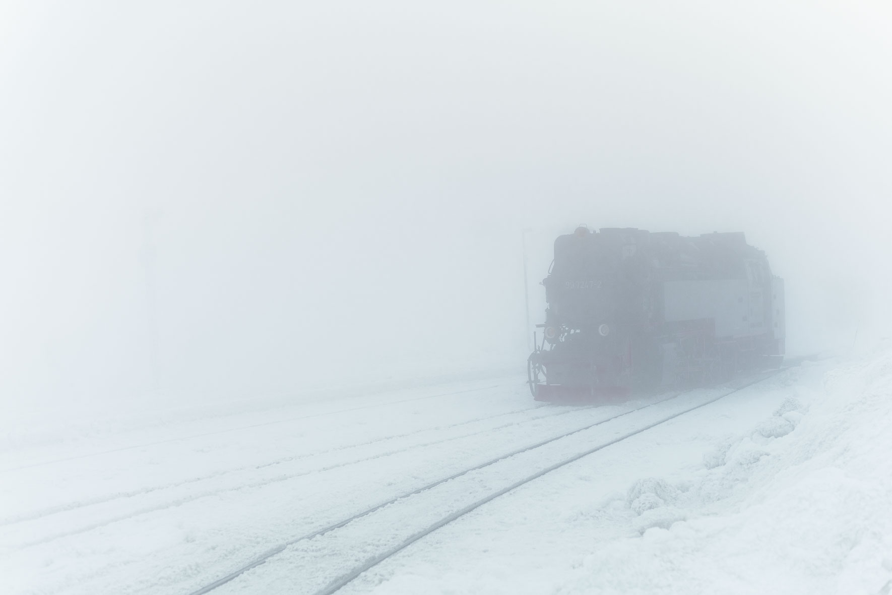 Old locomotive on snow covered train tracks on top of Mount Brocken in the Harz