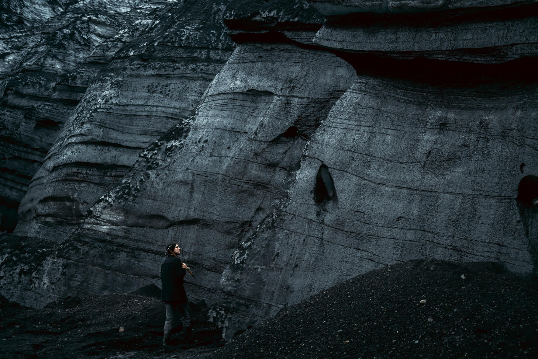 Dark ice of Kötlujökull, an outlet glacier of Mýrdalsjökull in Iceland with man standing in foreground