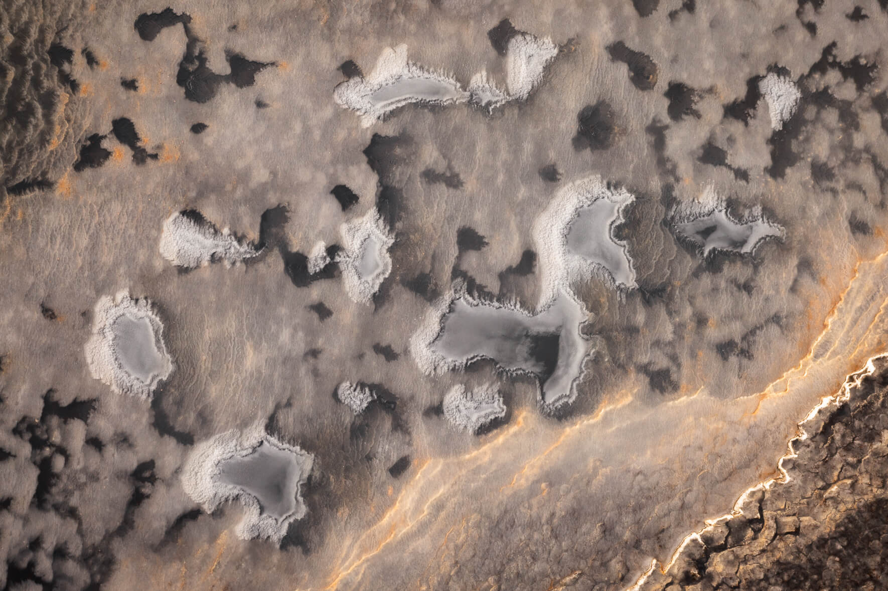 Abstract aerial photograph of frozen ponds with ice and sand in eastern Iceland