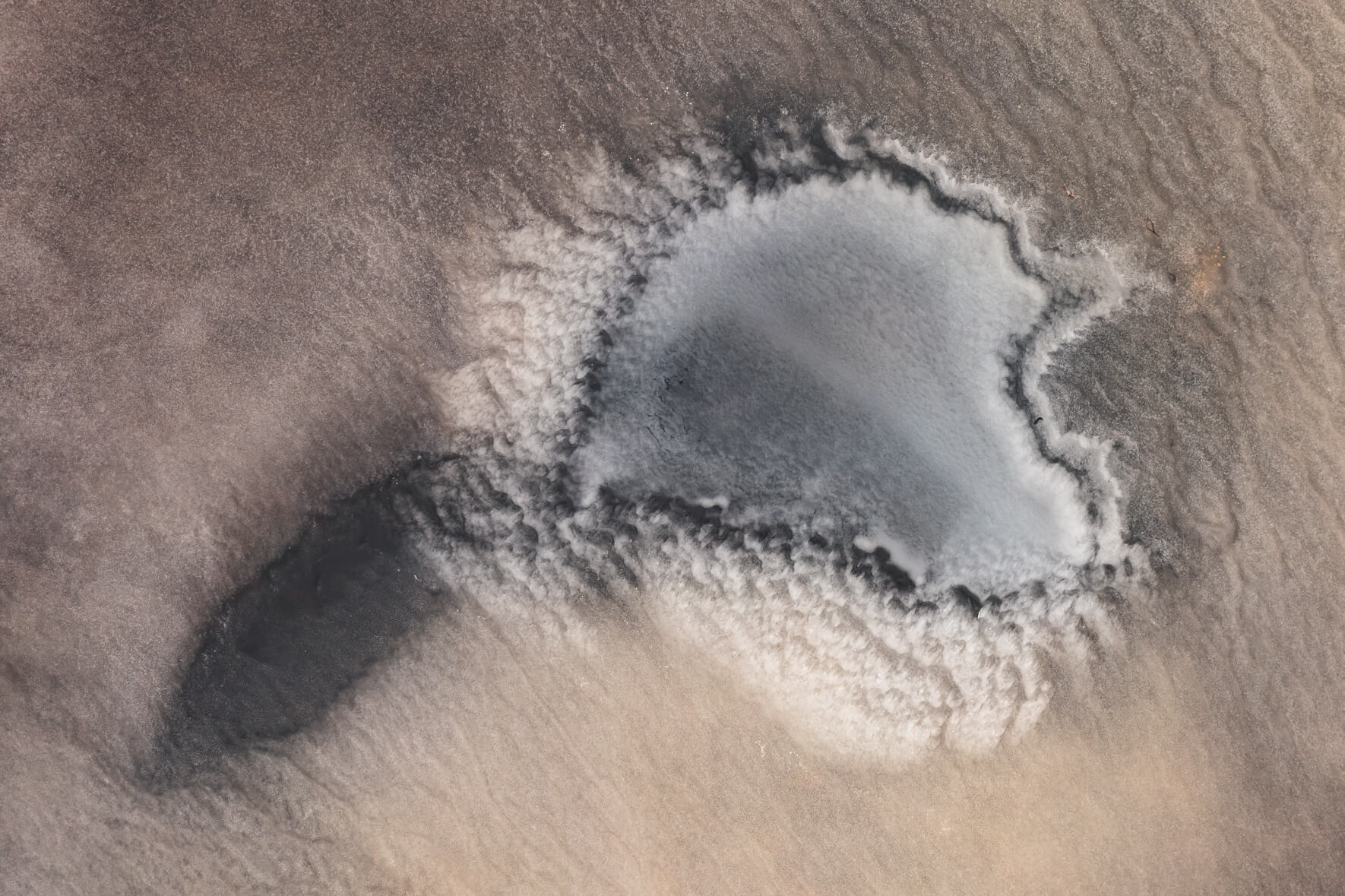 Aerial photo of a frozen pond on Jökuldalsheiði plateau in eastern Iceland