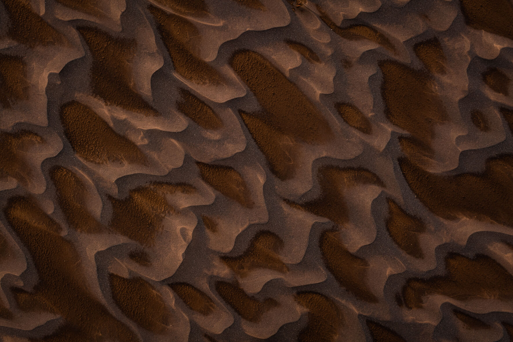 Dark sand in the highlands of Iceland, shaped by water and wind