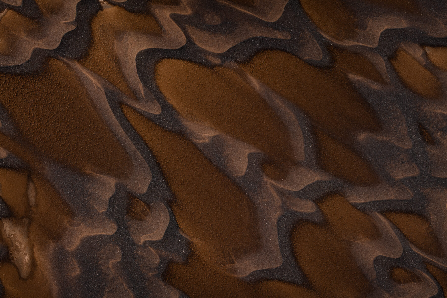 Dark sand in the highlands of Iceland, shaped by water and wind