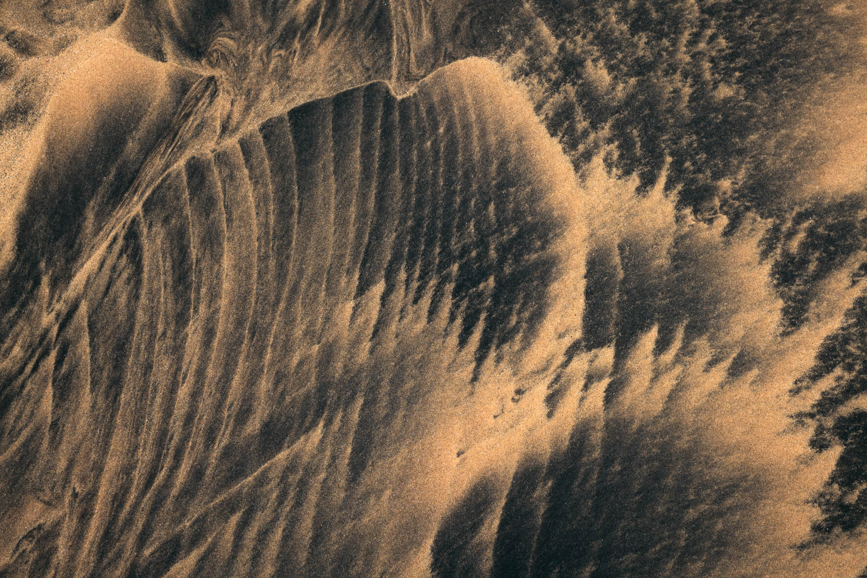 Abstract textures in sand painted by sea water in the Westfjords of Iceland