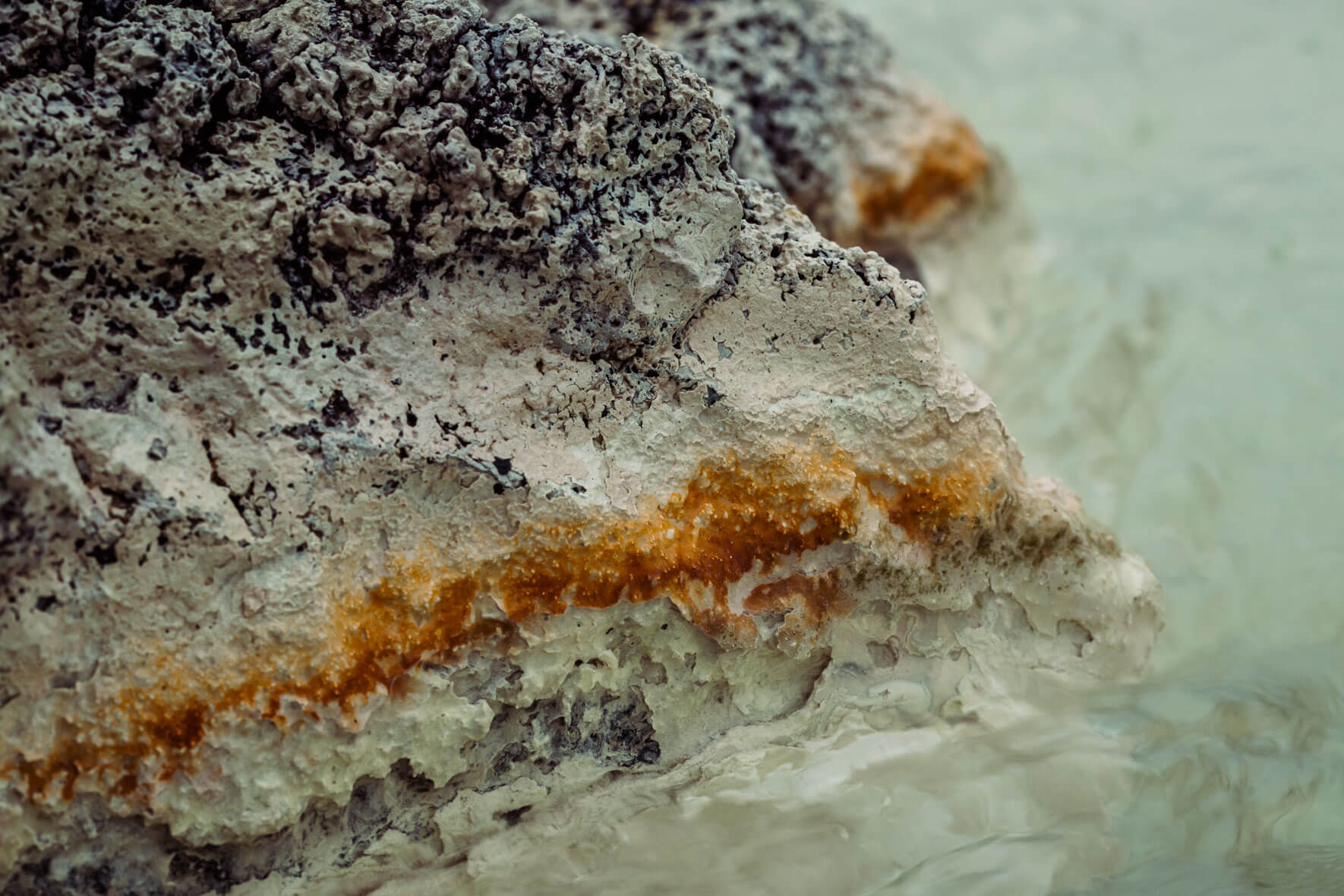 Abstract photography of rocks in a stream bed in a geothermal area in Mývatn region of Iceland