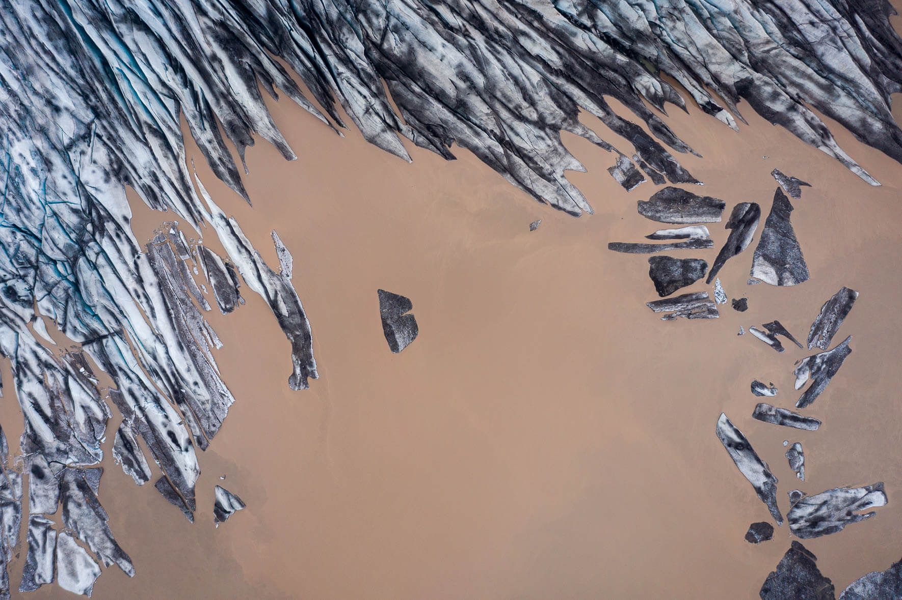 Aerial photograph of Fláajökull glacier in Iceland with glacial lake and individual icebergs