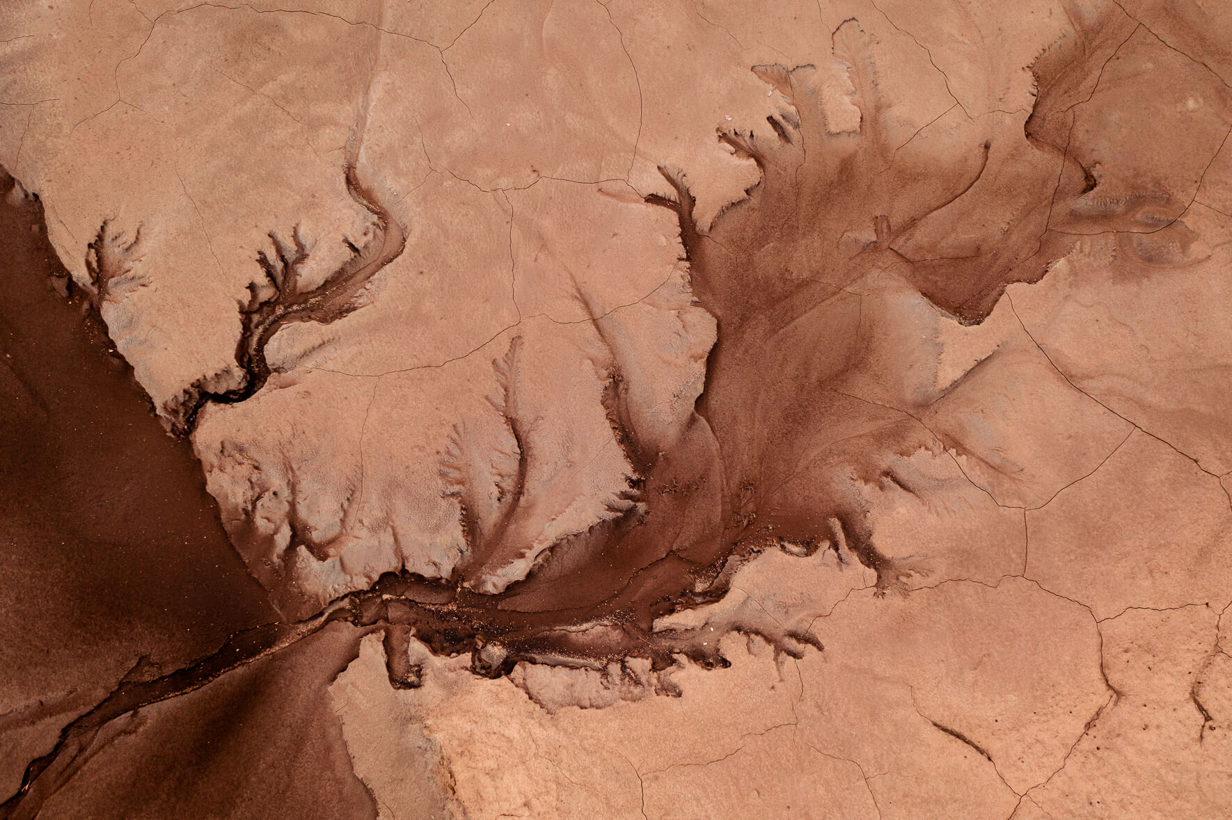 Aerial view of a dried up creek with cracked mud in the highlands of Iceland