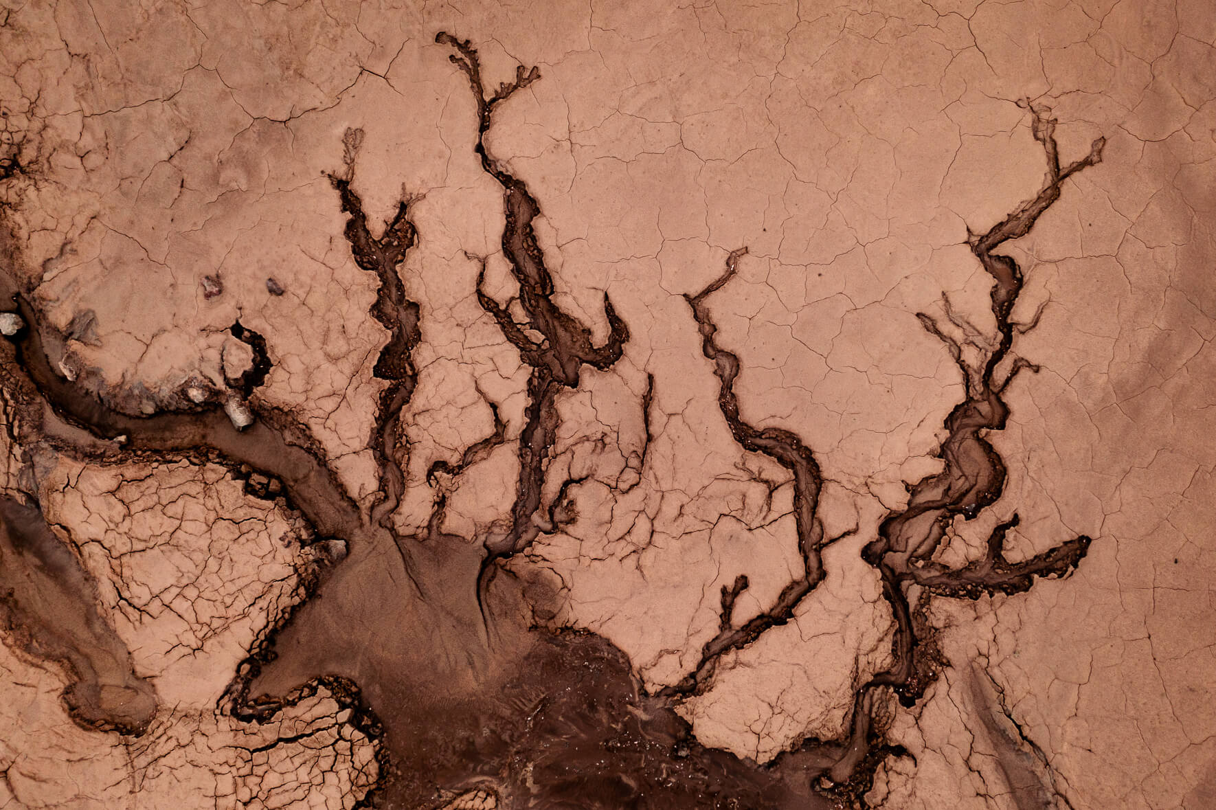 Aerial view of a dried up creek with cracked mud in the highlands of Iceland