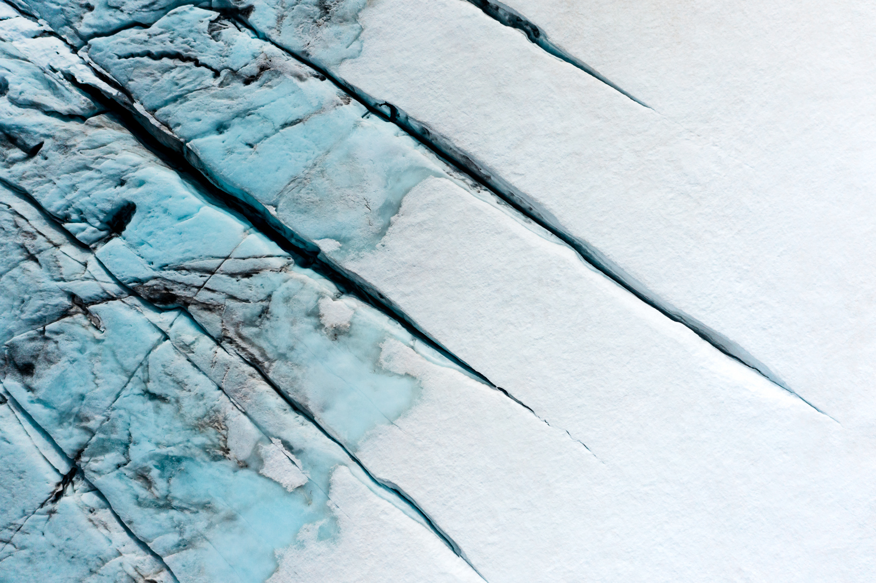 Aerial view of a snow-covered glacier in Norway with deep cracks and crevasses
