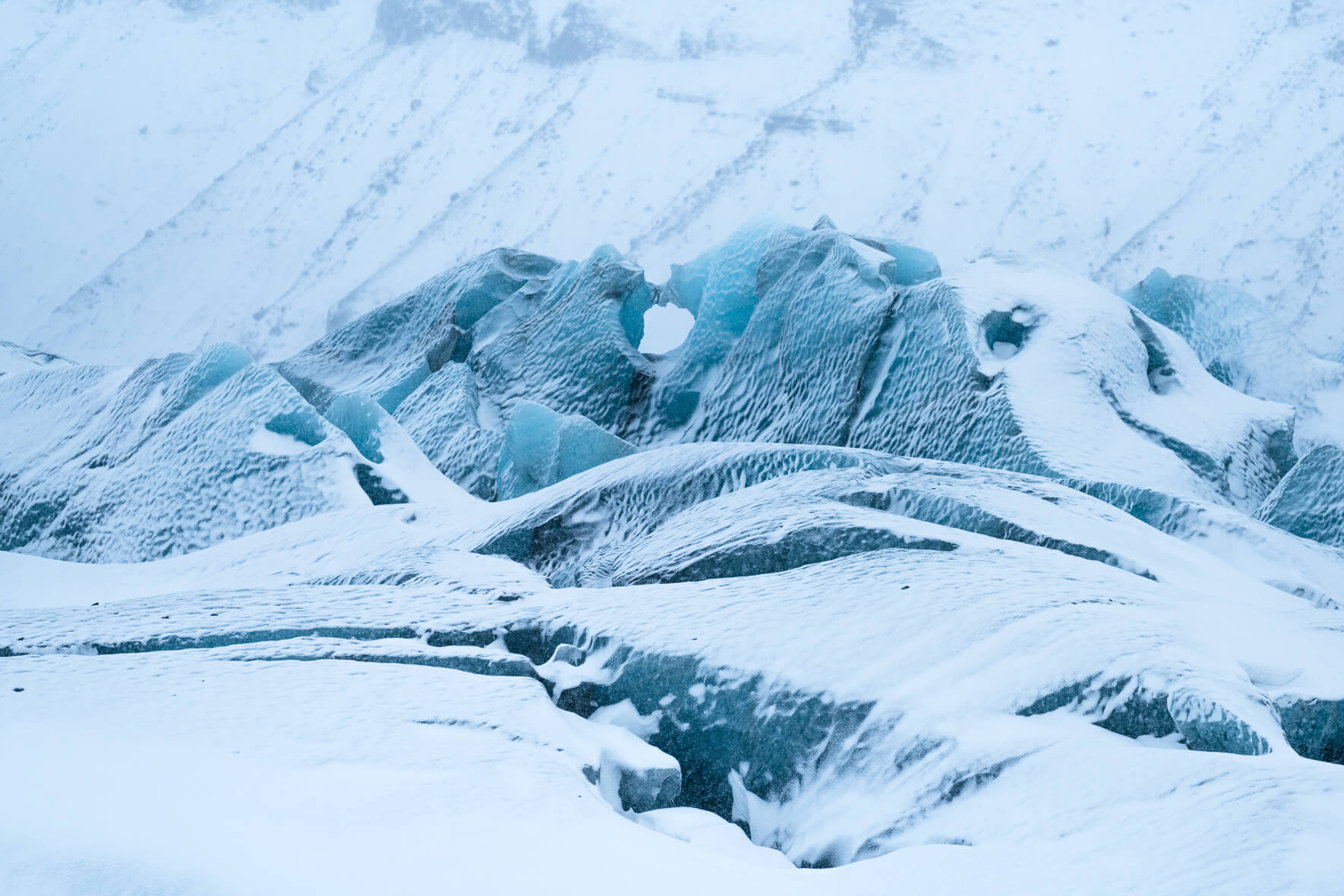 Svínafellsjökull glacier in winter with snow and blue glacier ice