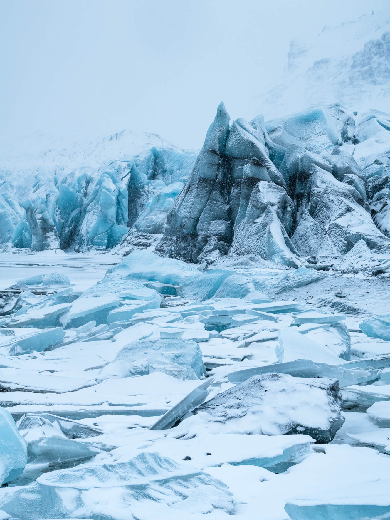 Snow-covered landscape of Svínafellsjökull glacier, surrounded by snowy mountains