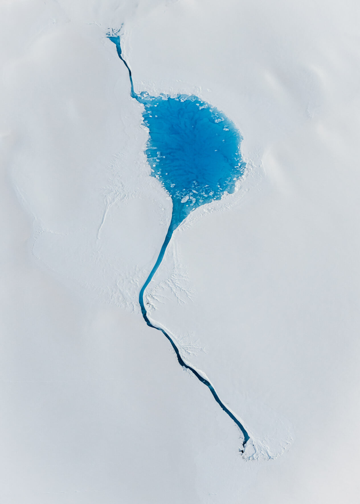 Aerial view of vivid blue meltwater lake on Columbia Glacier in Alaska