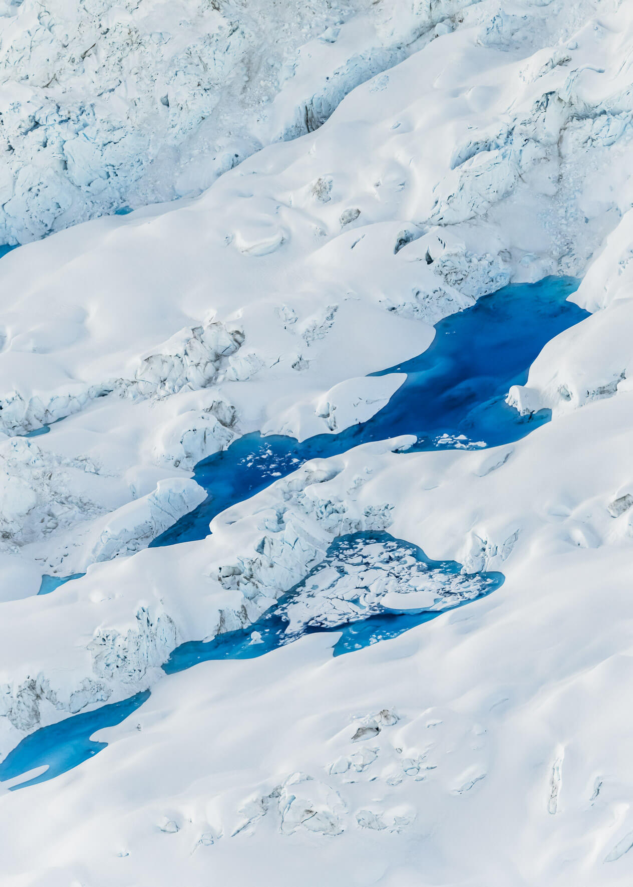 Aerial view of vivid blue meltwater lakes on Columbia Glacier, Alaska