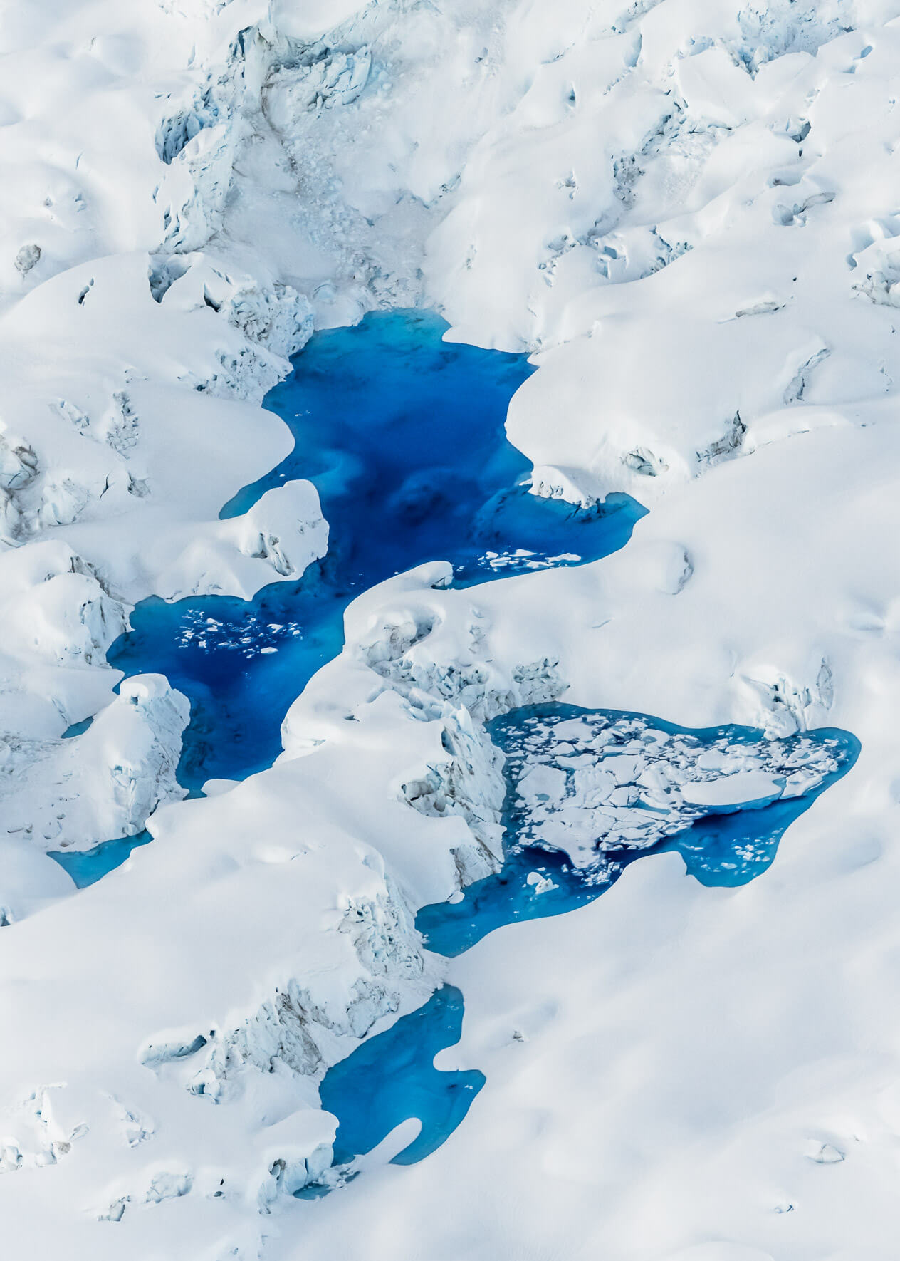 Glacial meltwater lakes with intense blue hues, seen from above in Alaska