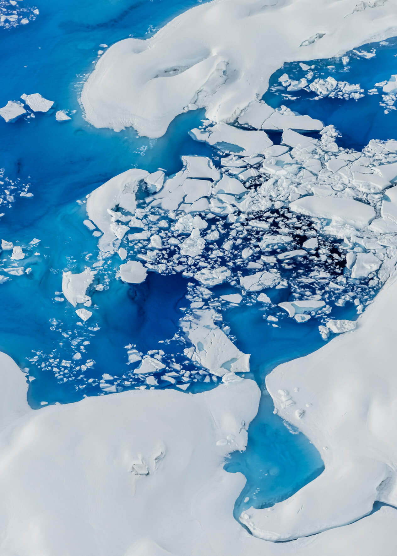 Aerial perspective of Columbia Glacier, showcasing striking blue meltwater formations