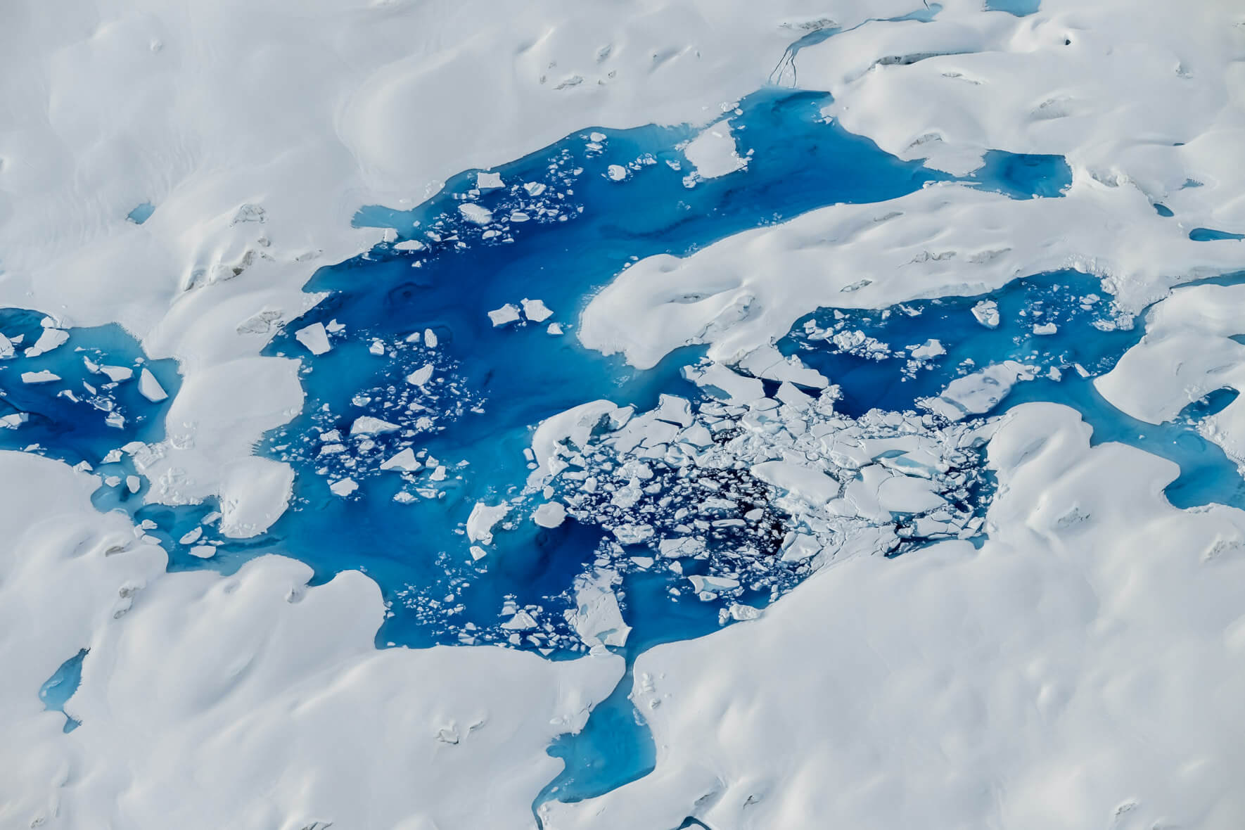 Aerial view of vivid blue and abstract meltwater lakes on Columbia Glacier, Alaska