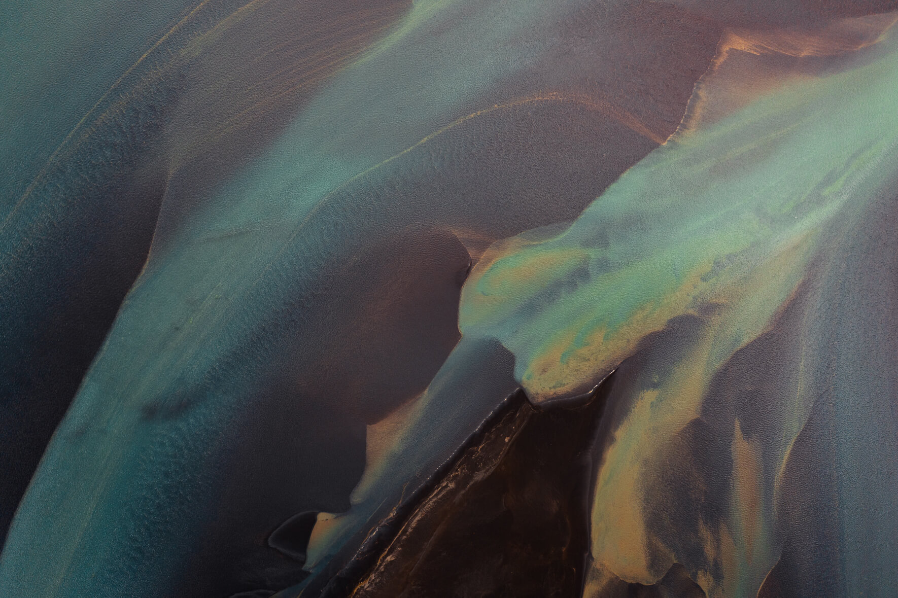 Colorful aerial view of a glacial river in Iceland with sandbanks