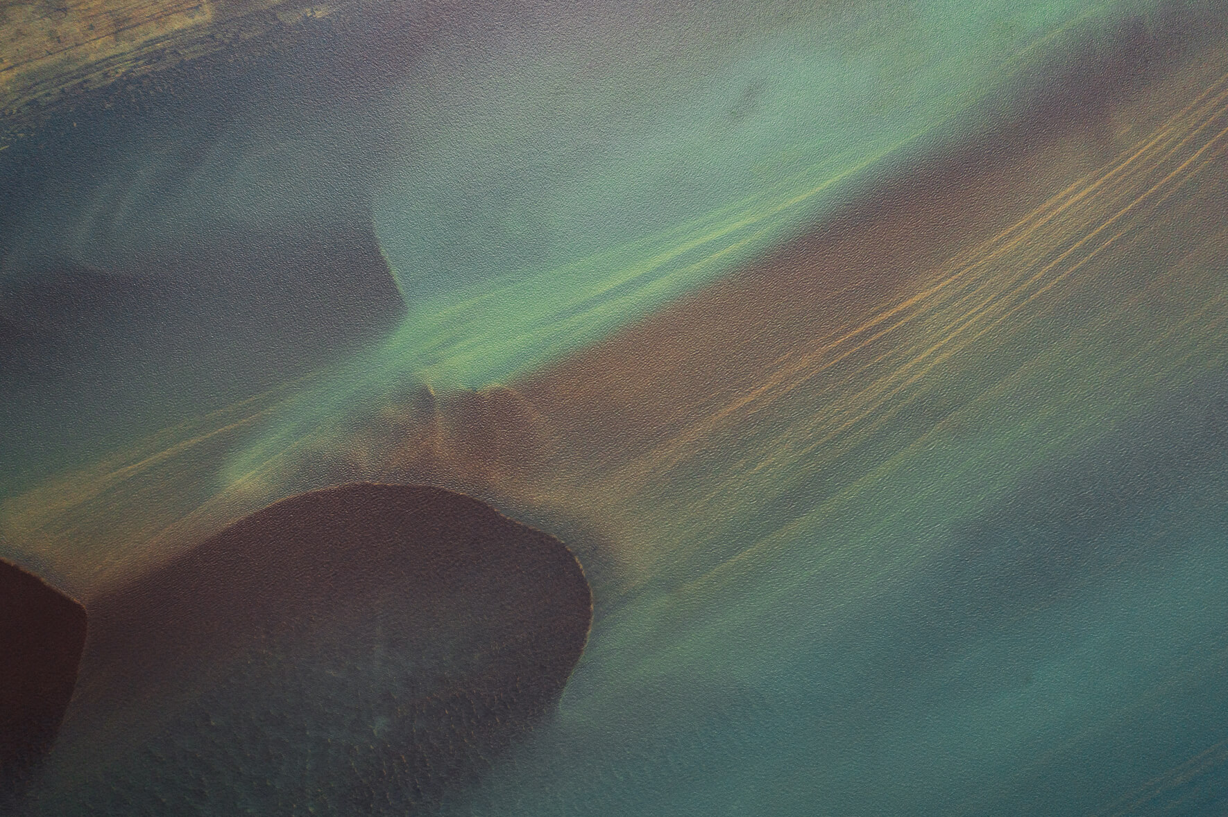 Colorful aerial view of a glacial river in Iceland with yellow sediments in the water