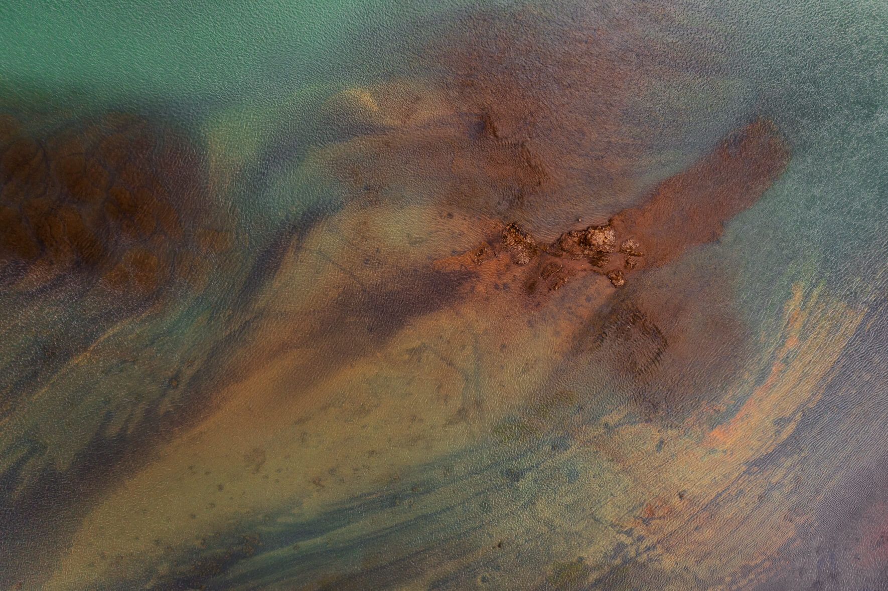 Aerial view of an abstract glacial river in Iceland with rocks in the water