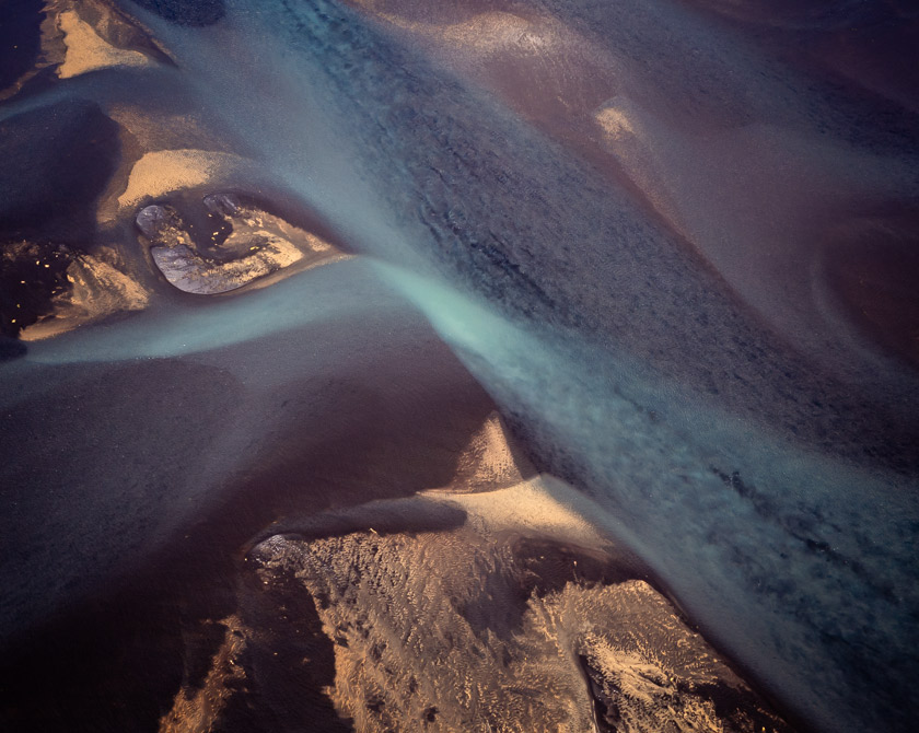 Aerial view of Iceland’s braided glacial rivers, showcasing intricate patterns and sediment-rich waters