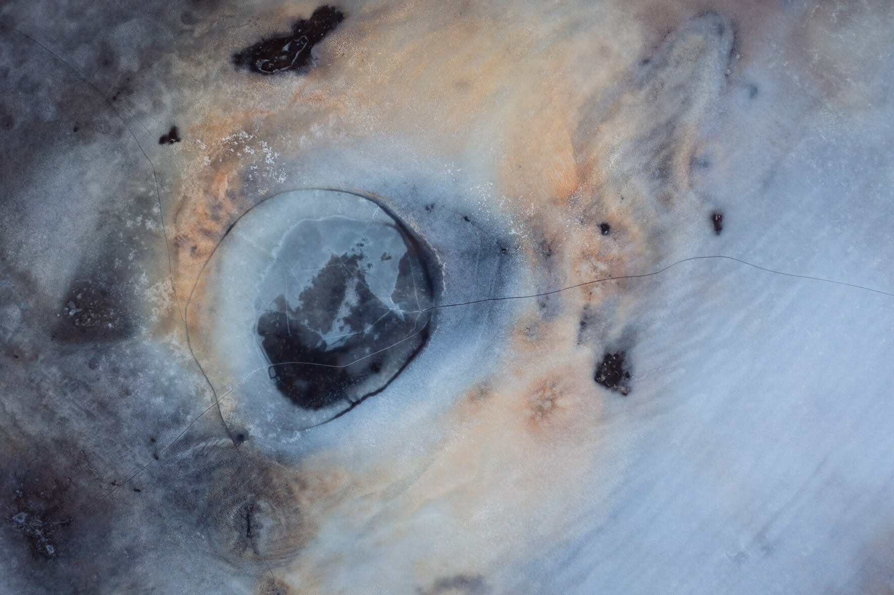 Aerial perspective of frozen wetlands in Iceland, highlighting frost-covered terrain