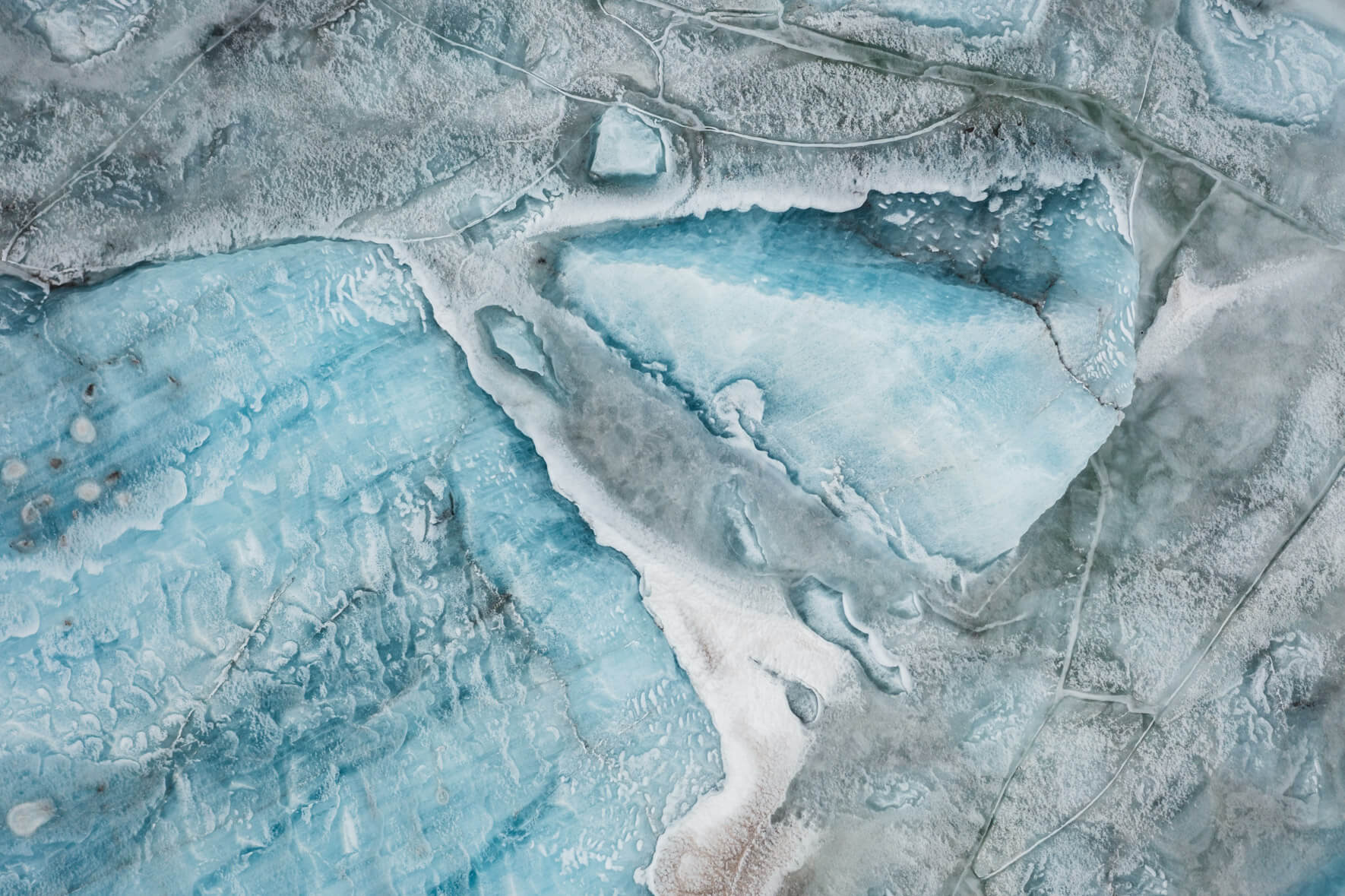 Iceland’s Svínafellslón lagoon from above, revealing dynamic ice patterns and natural color variations