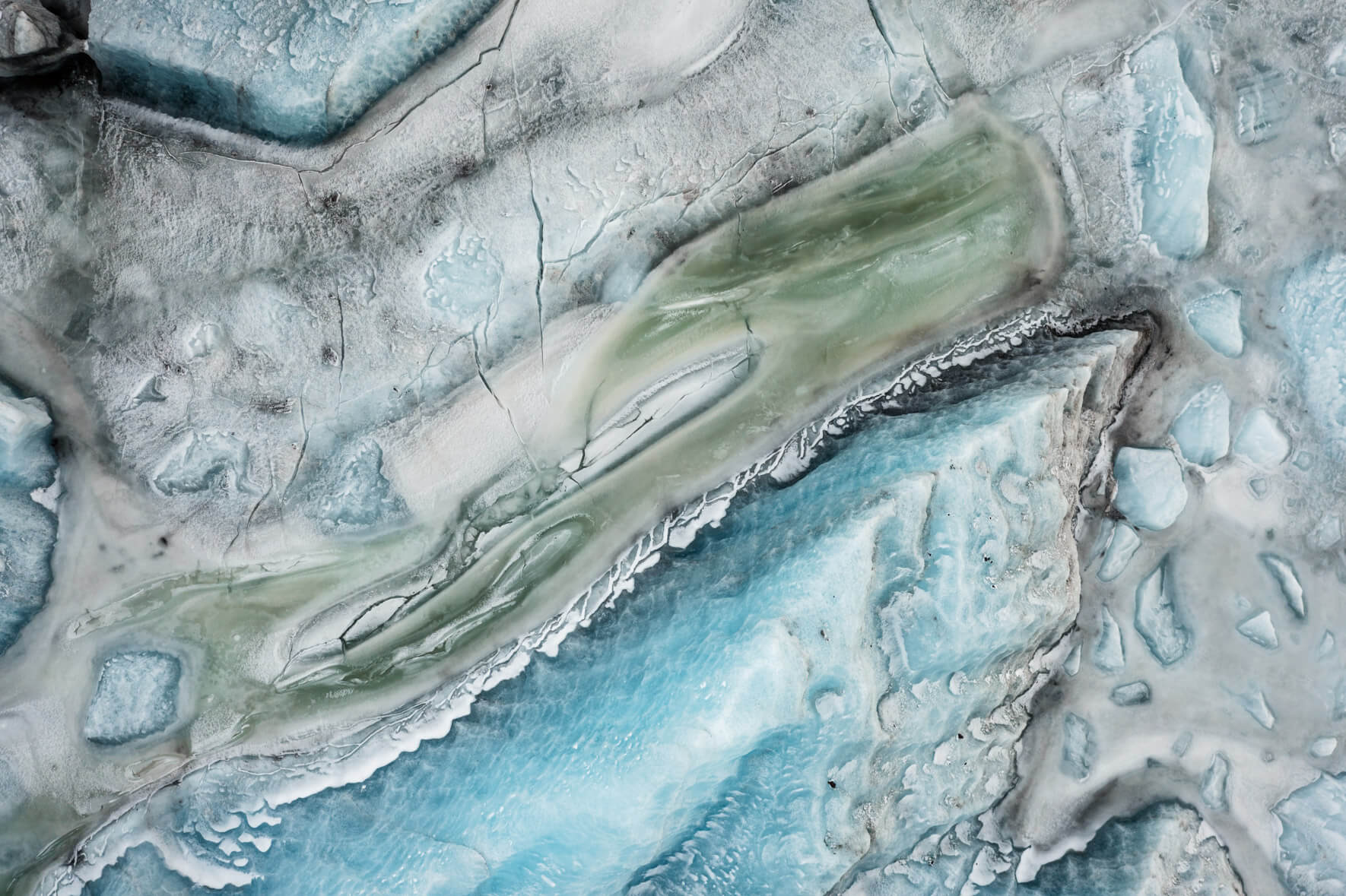 Aerial abstraction of Svínafellslón, where melting and refreezing cycles create intricate textures