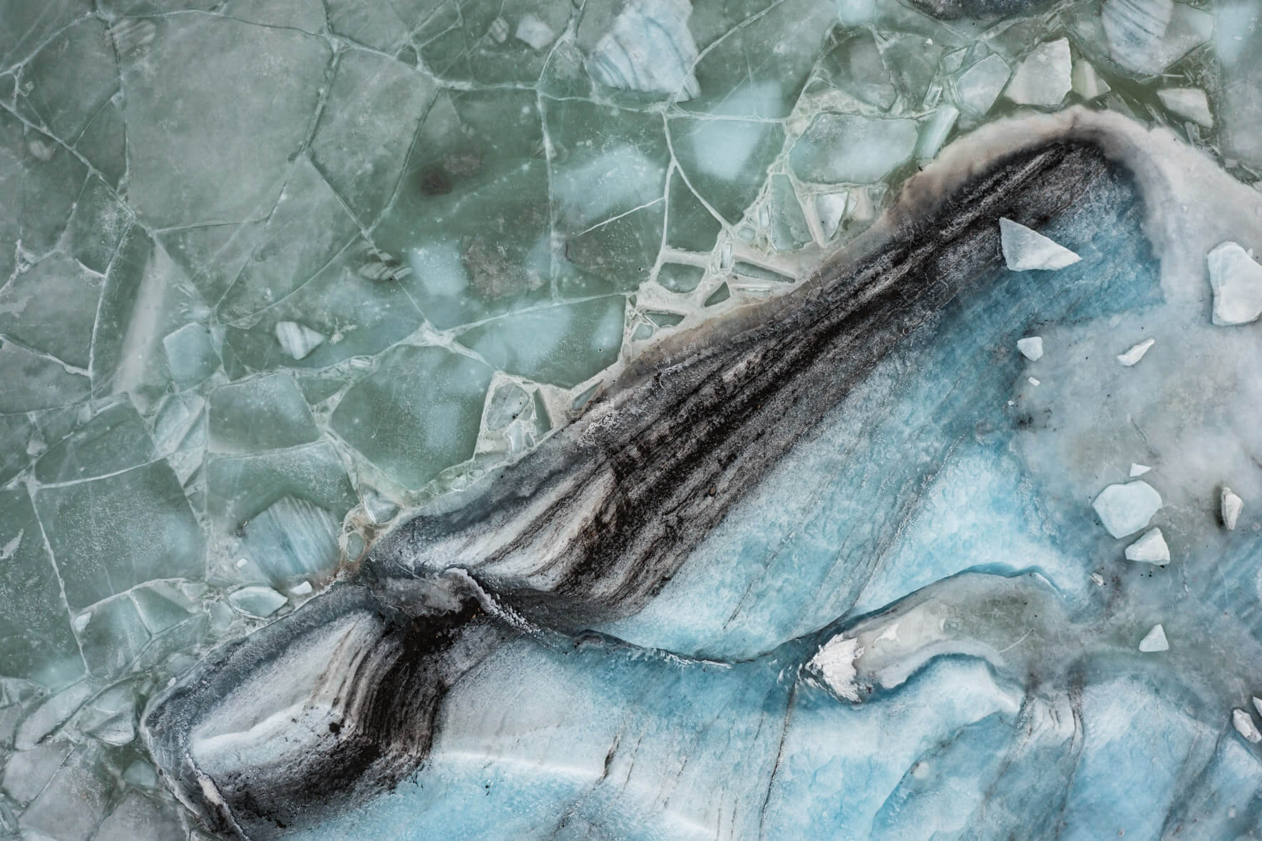 Aerial view of Svínafellslón glacial lagoon in Iceland, with vibrant ice textures and cracks