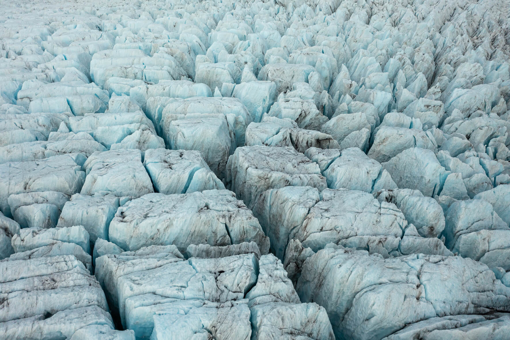 Aerial photograph of Fjallsjökull glacier in Iceland with deep and dark crevasses