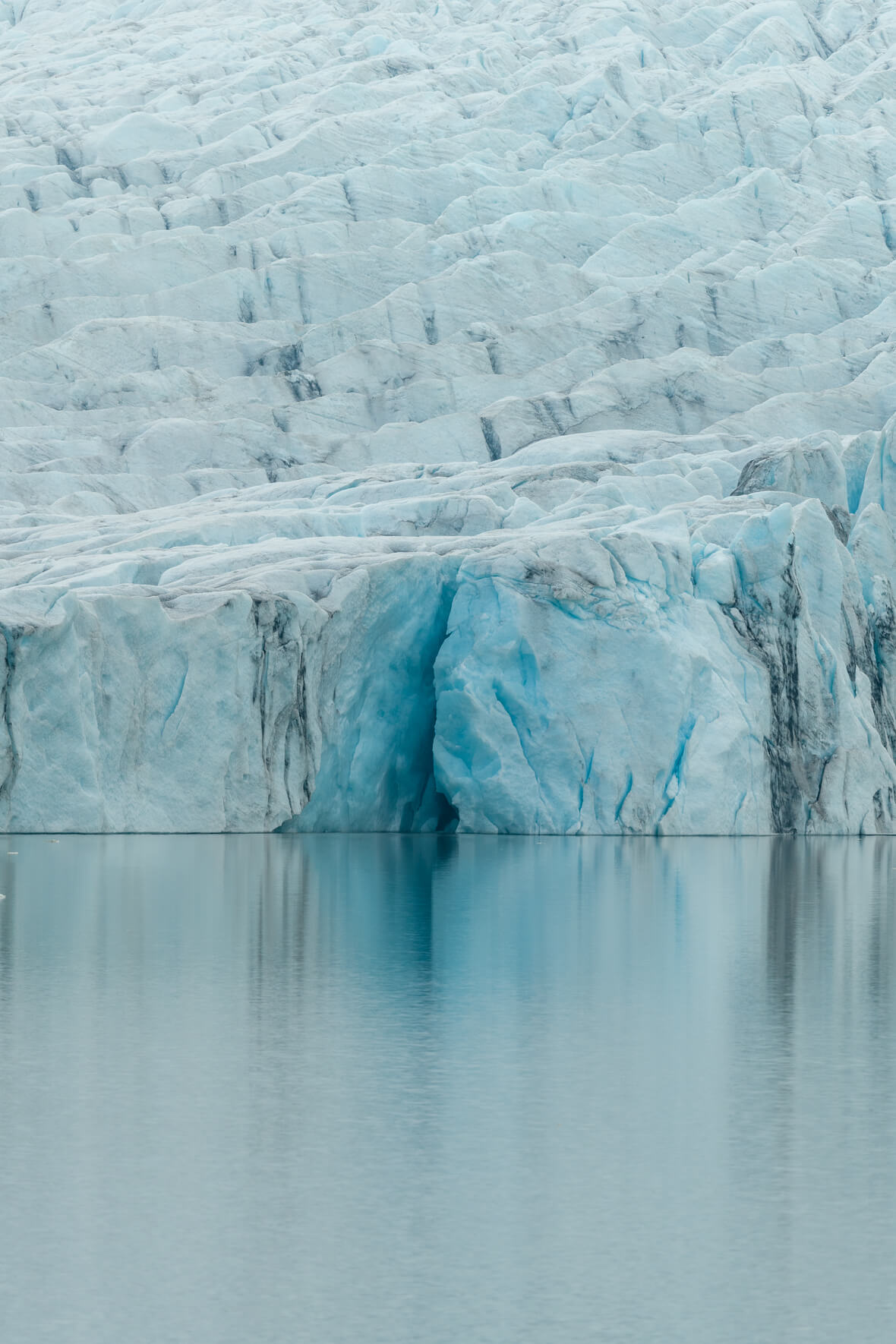 Fjallsárlón lagoon with the edge of the Fjallsjökull glacier and reflections in the water